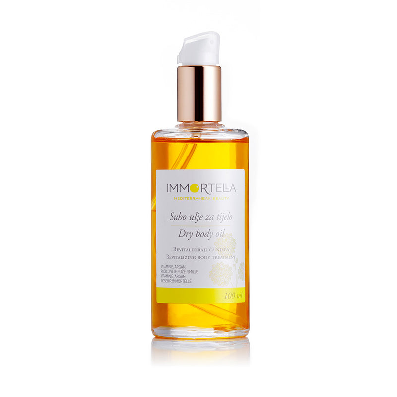 Beautiful golden immortelle dry body oil. A glass bottle of the oil on the white background.