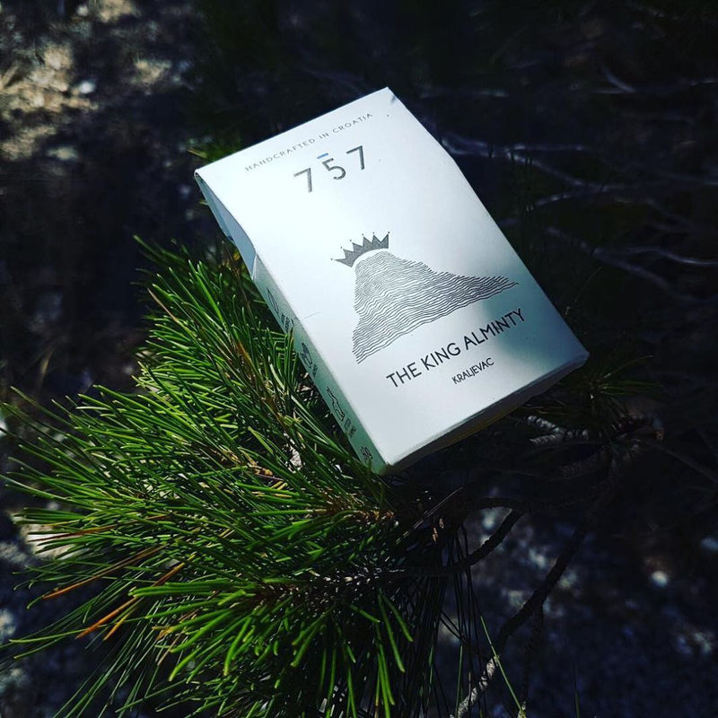 Close up of soap packaging lying on Mediterranean pine tree. There is one sun ray on the product which emphasizes the drawing on the packaging. Soap inside is made of extra virgin Croatian olive oil, and pure mint, clove and cinnamon essential oils. Packaging is made of eco-friendly, 100% recyclable paper.
