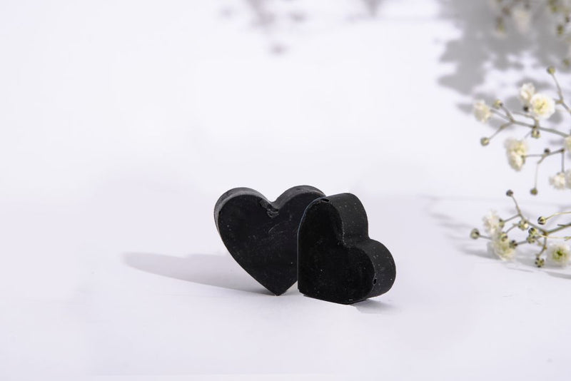 Two little cute hart shaped black soaps with beautiful small white flowers. Cold processed soap with charcoal and tea tree essential oil.