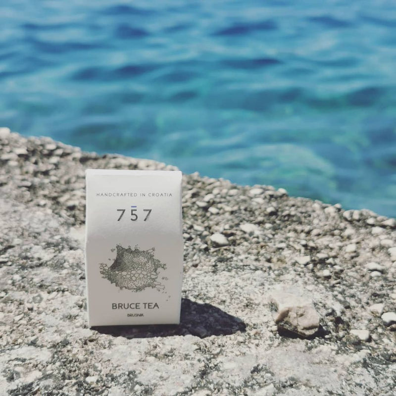 Natural, handmade soap in its white packaging, in front of a beautiful sea.