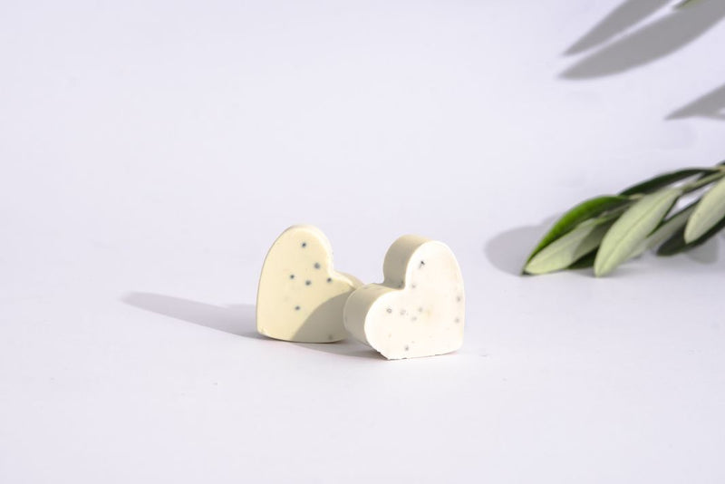 Close up of two little cute hart shaped soaps made of extra virgin Croatian olive oil, and pure mint, clove and cinnamon essential oils. Inside of natural soaps you can see the little poppy seeds.